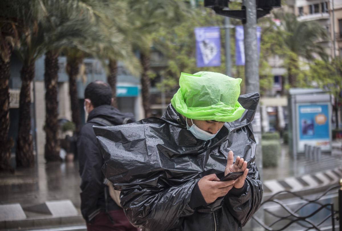 Un hombre se cobija de la lluvia con bolsas.