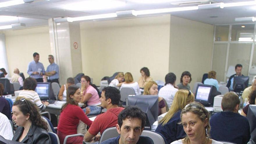 Renta. Dos contribuyentes hacen la declaración en Hacienda.