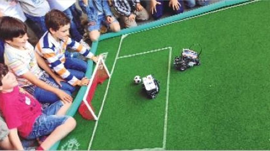 Los niños disfrutan de un partido de fútbol entre robots en la jornada de Expociència.