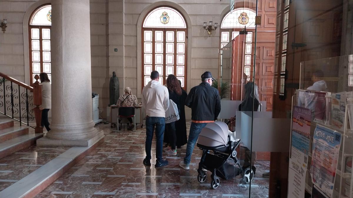 Personas haciendo cola para adquirir el Cheque Consumo, esta mañana en la planta baja del ayuntamiento.