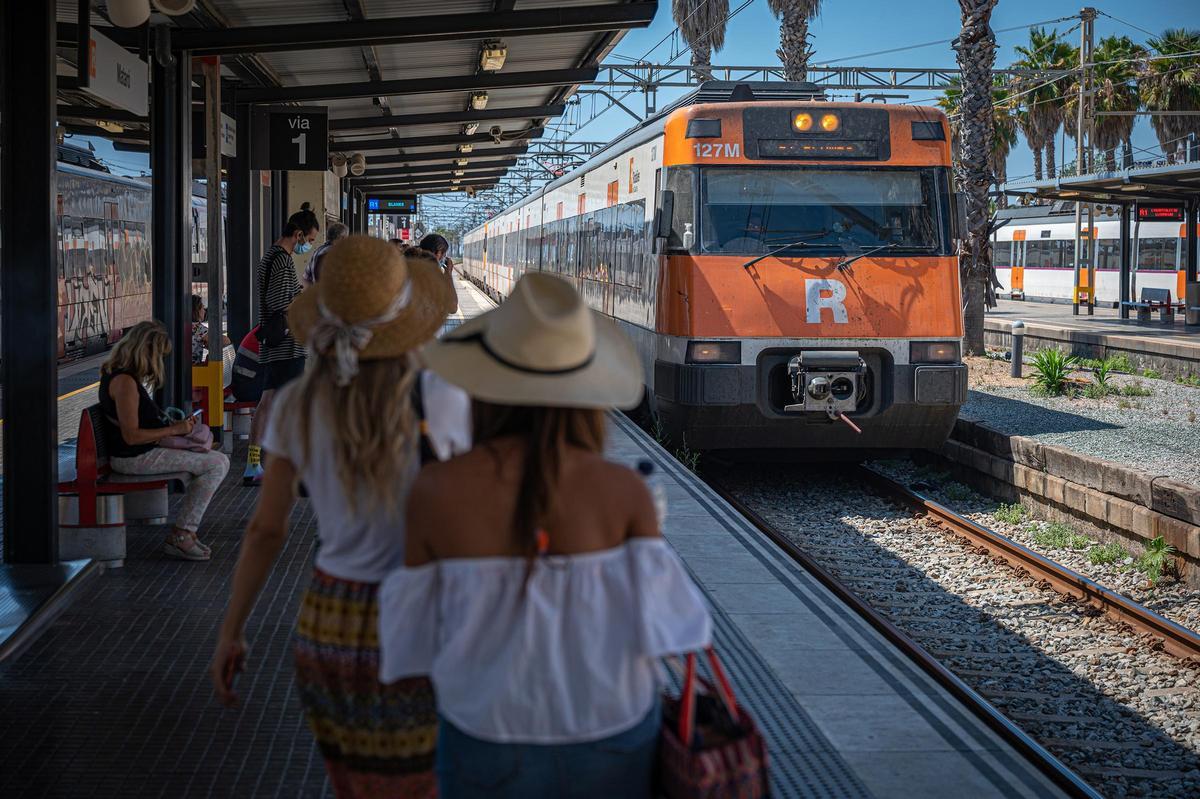 Pasajeros espando el tren en una estación de la R1