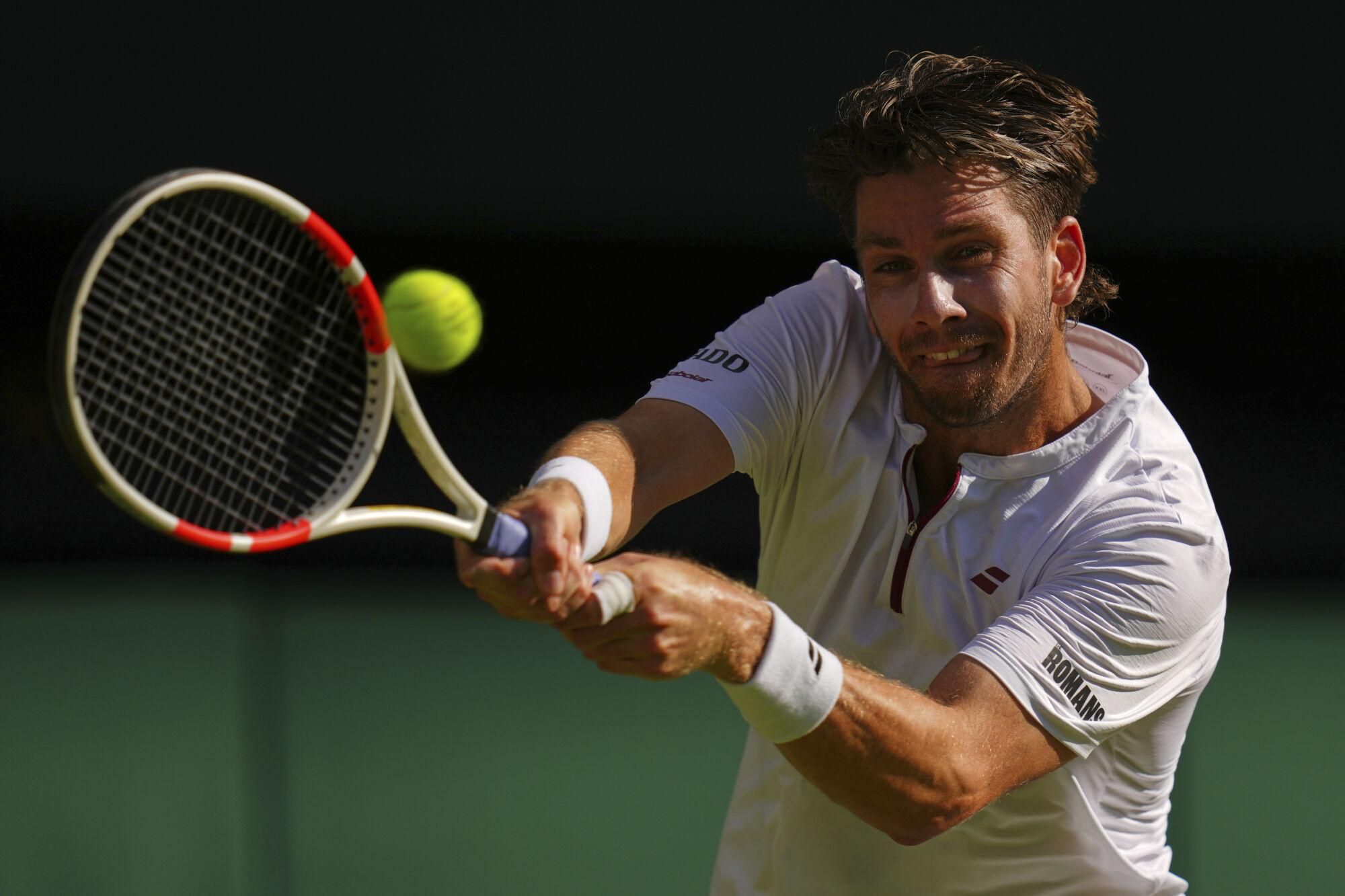 Britain's Cameron Norrie returns to Spain's Carlos Alcaraz during a quarterfinal men's singles match at the Wimbledon Tennis Championships in London, Tuesday, July 8, 2025. (AP Photo/Kirsty Wigglesworth)