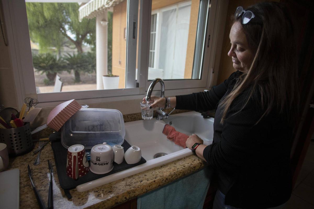 Una vecina del Carraixet llena un vaso de agua no apta para consumo humano.