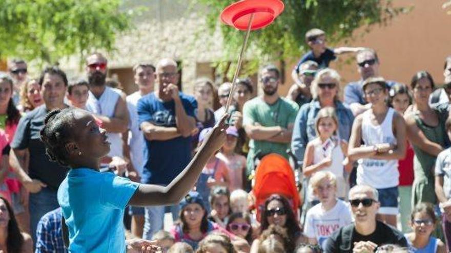 Una de les nenes participants a la mostra del circ social demostrant les seves habilitats com a malabarista de plats xinesos