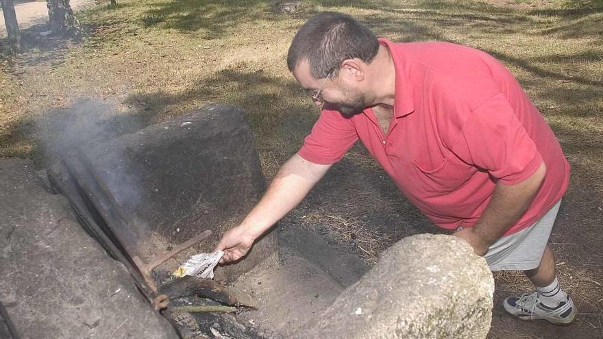 Pablo Martínez, en 2005, haciendo brasas en Beade. // P.M.