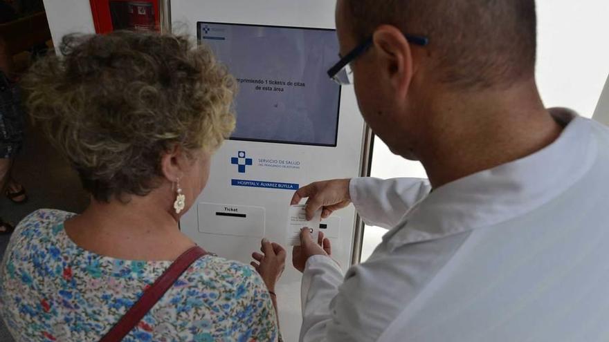 Un sanitario ayuda a una paciente a utilizar la máquina de citaciones del Álvarez-Buylla.