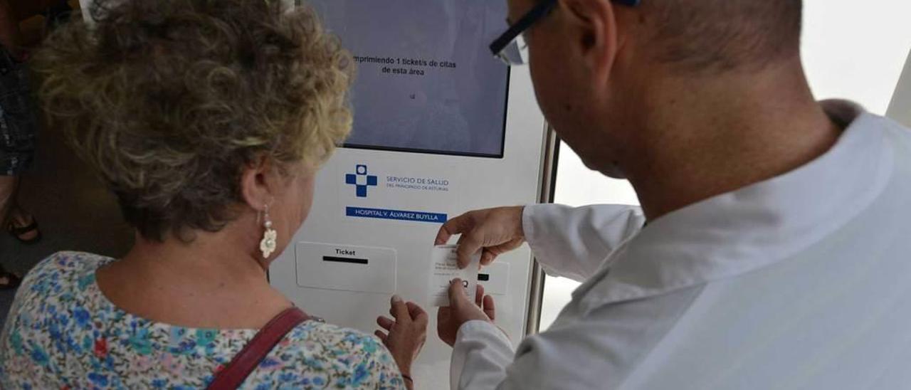 Un sanitario ayuda a una paciente a utilizar la máquina de citaciones del Álvarez-Buylla.