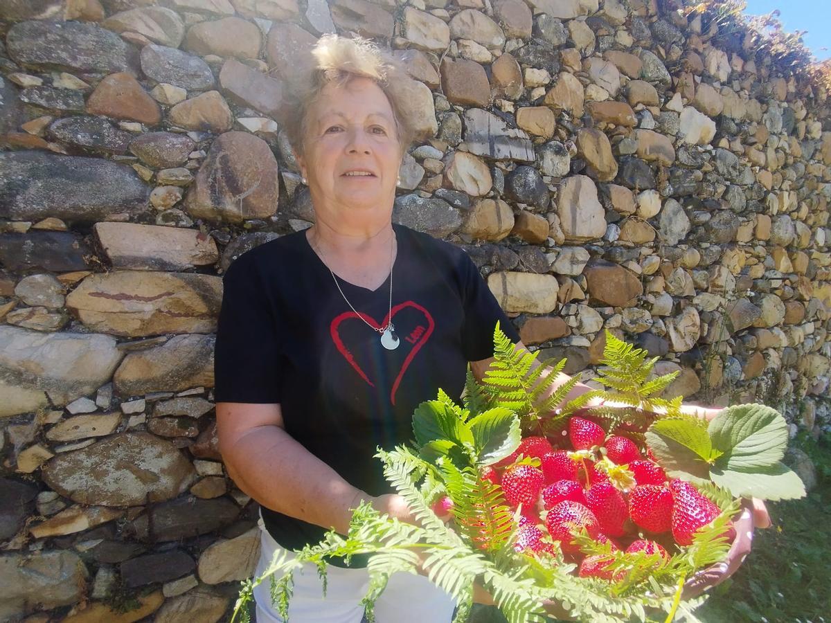 Cruz Arango muestra una cesta llena de fresas de su huerta de Santoseso.