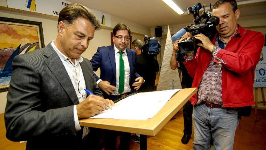 Bernardo Salom firma el acta como presidente ante Marcos Cabrera.