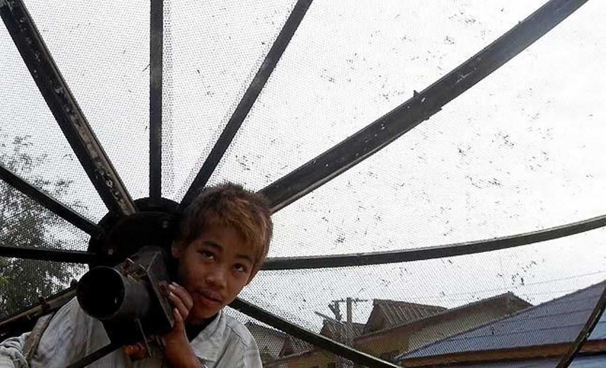 Un nen porta una antena parabòlica recollida d’una casa destruïda pel terratrèmol que el 24 de març va afectar Myanmar i va provocar almenys 74 morts.