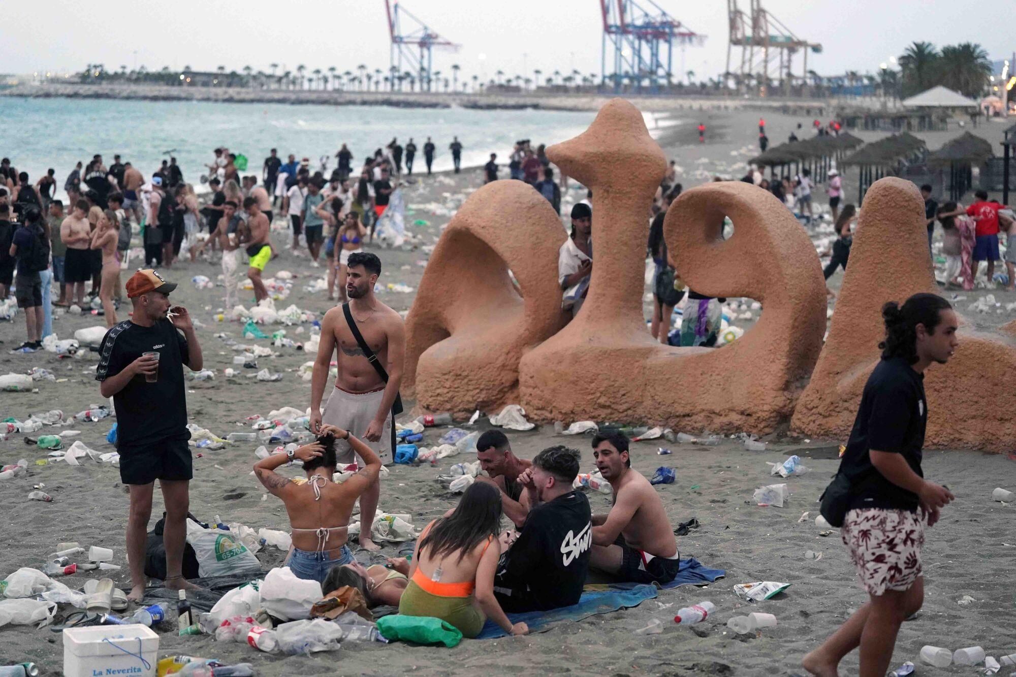 Varios operarios de la empresa de limpieza de Limasam, recogen los residuos de la playa de La Malagueta, tras la Noche de San Juan en Málaga 2025