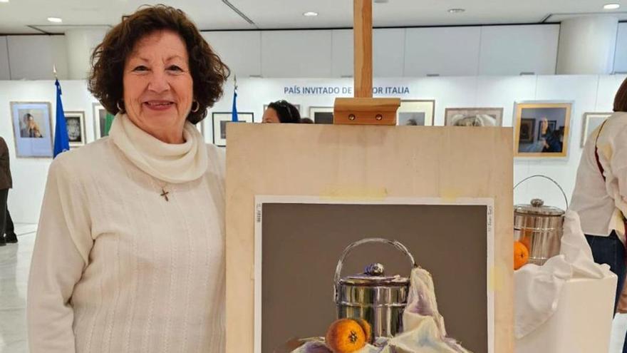 María Dolores Gil posa junto a una de sus obras en la Bienal.