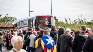 Asistentes al mitin de Puigdemont a su llegada con los autobuses de campaña