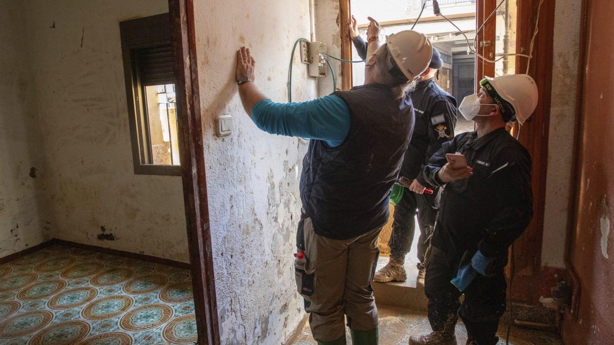 Dos electricistas trabajan en una vivienda en obras.