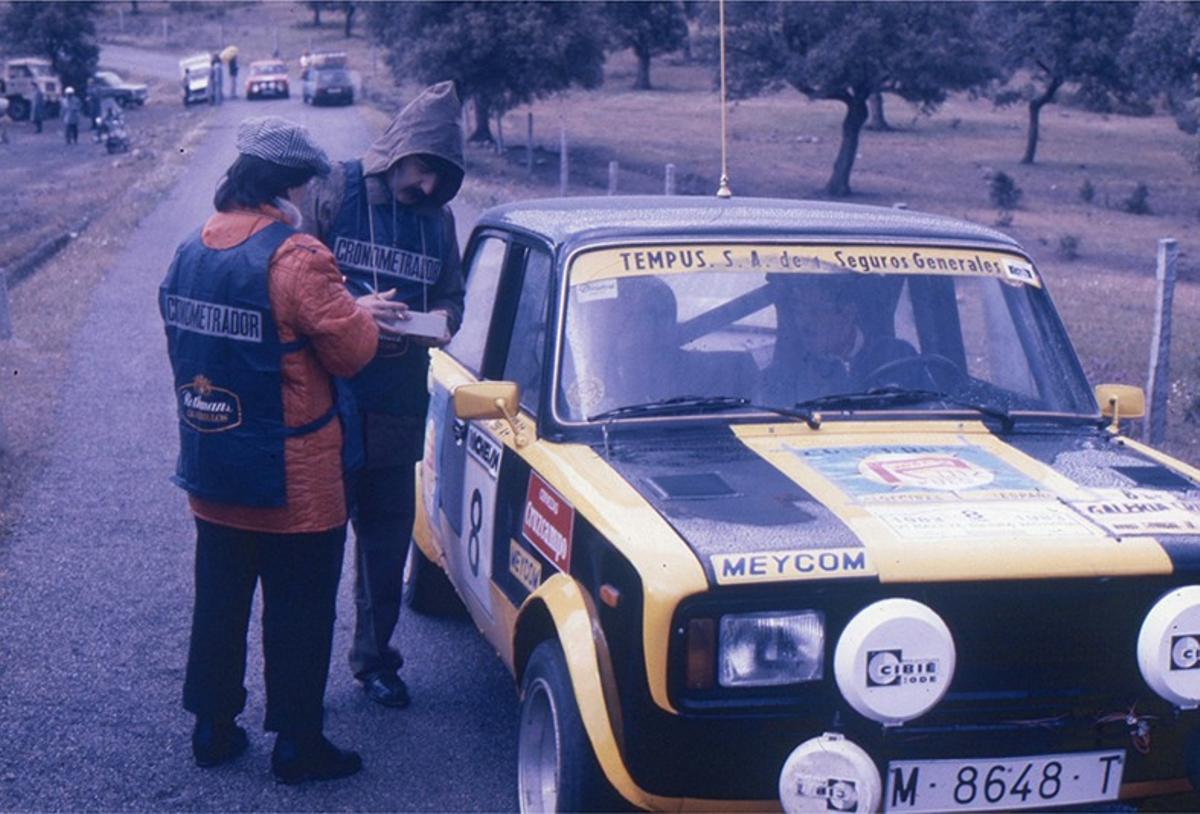Dos cronometradores de las primeras ediciones anotan datos en el carnet de ruta de uno de los participantes del Rally Sierra Morena.