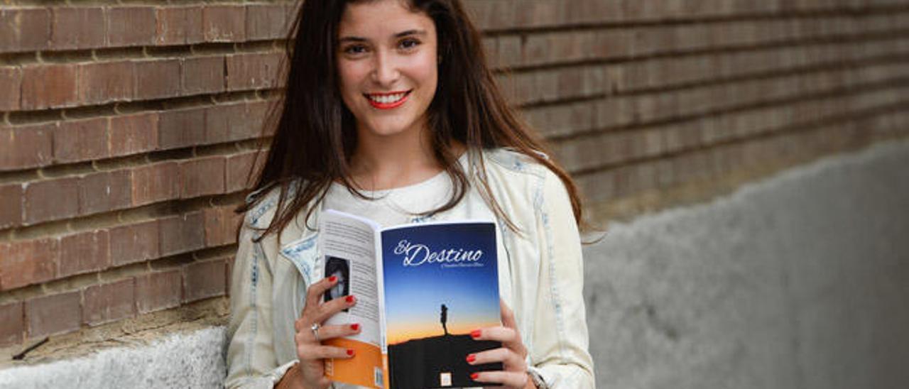 Claudia García Báez sostiene un ejemplar de su libro de poesía &#039;El destino&#039;.