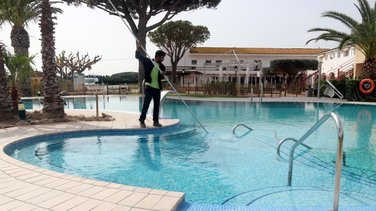 Un treballador netejant la piscina del càmping Les Medes de l'Estartit.