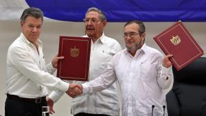 HAB01. LA HABANA (CUBA), 23/06/2016.- El delegado de las FARC en Cuba, Rodrigo Londoño Echeverri, alias Timochenko (d) y el presidente de Colombia, Juan Manuel Santos (i) junto a el presidente de Cuba, Raúl Castro (c) sostienen en sus manos el acuerdo de paz entre el Gobierno colombiano y las FARC, durante la ceremonia en La Habana (Cuba) hoy, jueves 23 de junio de 2016, del acuerdo para el cese al fuego en Colombia. El acto para oficializar el acuerdo de cese al fuego bilateral y definitivo en Colombia comenzó hoy en La Habana, encabezado por el presidente Juan Manuel Santos y por Timochenko, máximo líder de las FARC, y con la asistencia de seis presidentes de la región y el secretario general de la ONU. EFE/ALEJANDRO ERNESTO