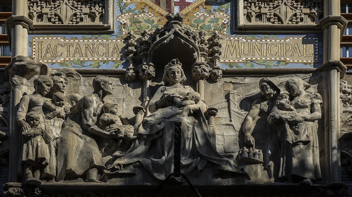Barcelona amamanta a sus hijos biberón en mano, el conjunto escultórico de Eusebi Arnau del frontón de la Casa de la Lactancia. 