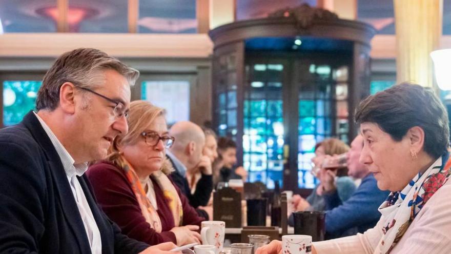 Pablo González, con Carmen Moreno enfrente, en presencia de Carmela Llanos, secretaria de comercio del PP de Gijón. | LNE