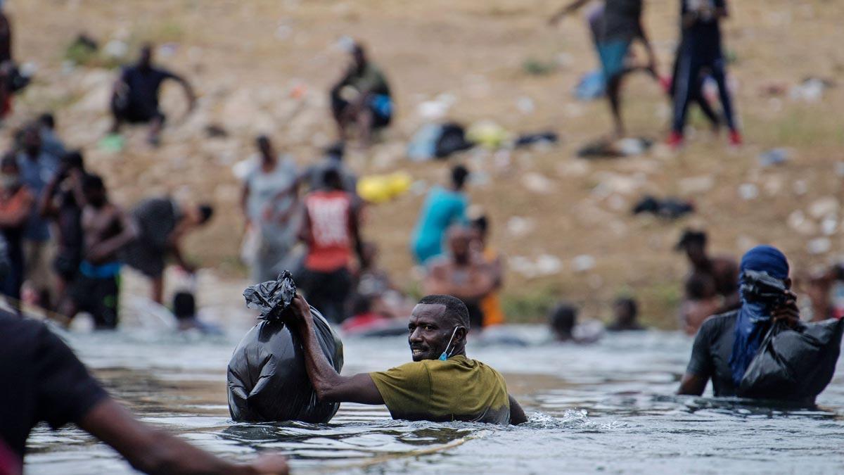 Un inmigrante haitiano cruza el Río Grande para obtener comida y agua en México