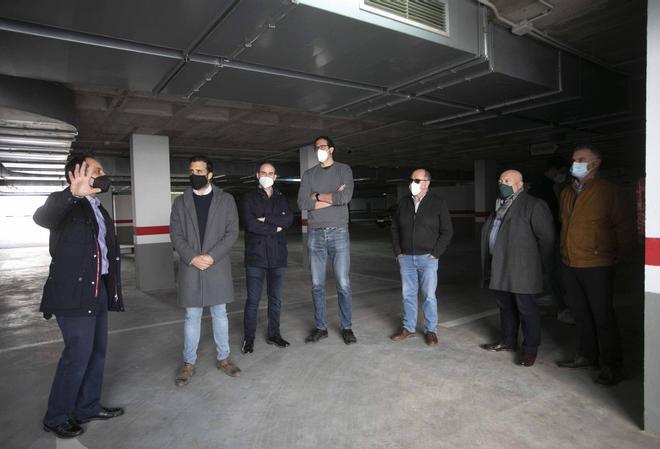 Un responsable del parking, explicando los detalles al alcalde, ediles y otros asistentes.