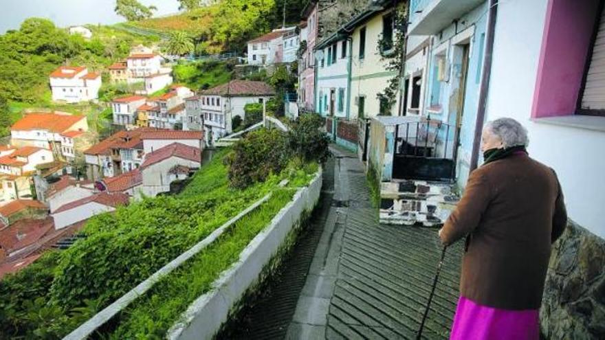 el horizonte. Una señora mira hacia el anfiteatro de Cudillero desde la calle Cimadevilla. / ricardo solís