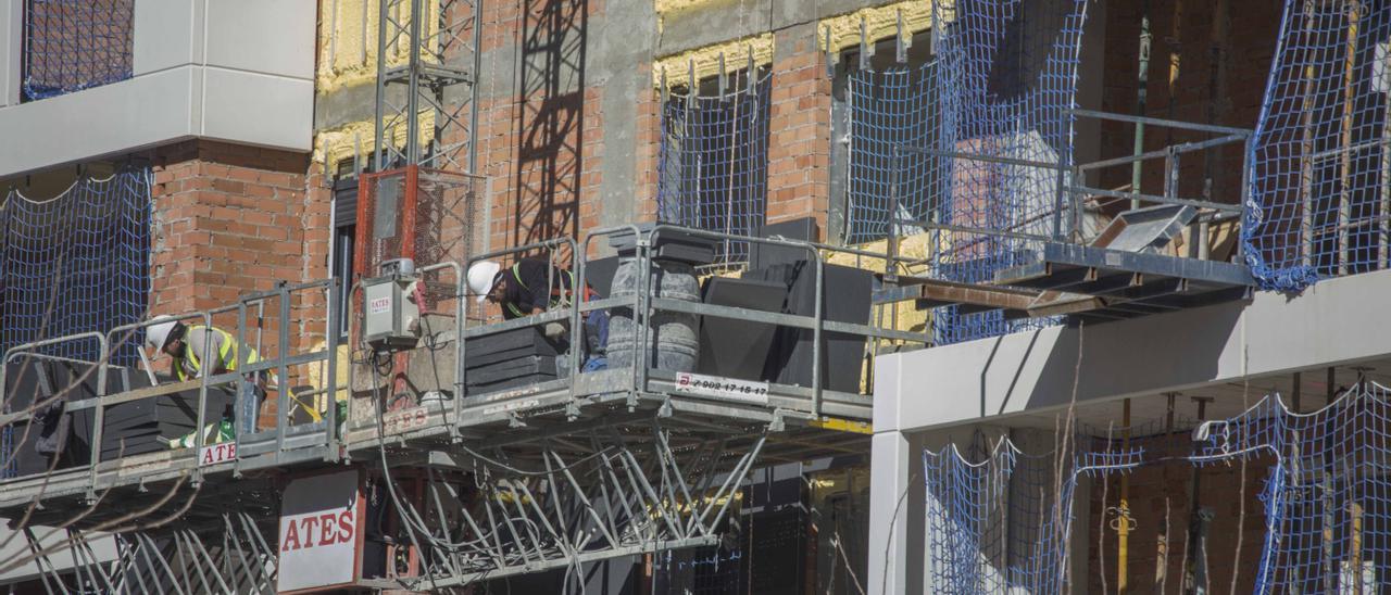 Dos obreros trabajan en la construcción de un edificio en el Pau 2 de Alicante.