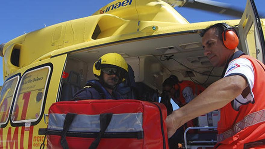 Uno de los pilotos del helicóptero y Ángel Crespo suben al aparato para hacer un traslado.