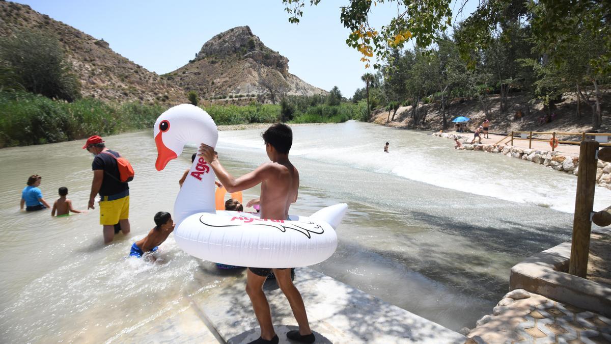 Varios niños juegan en una de las playas fluviales de la Región, en concreto Archena.