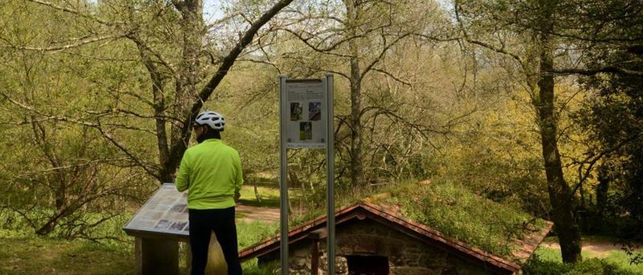 Un ciclista descansa junto a los molinos de la Ruta da Pedra e da Auga. |   // NOÉ PARGA