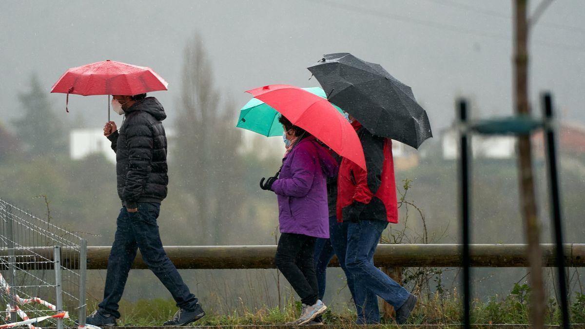 Ciudadanos protegiéndose de la lluvia con los paraguas.