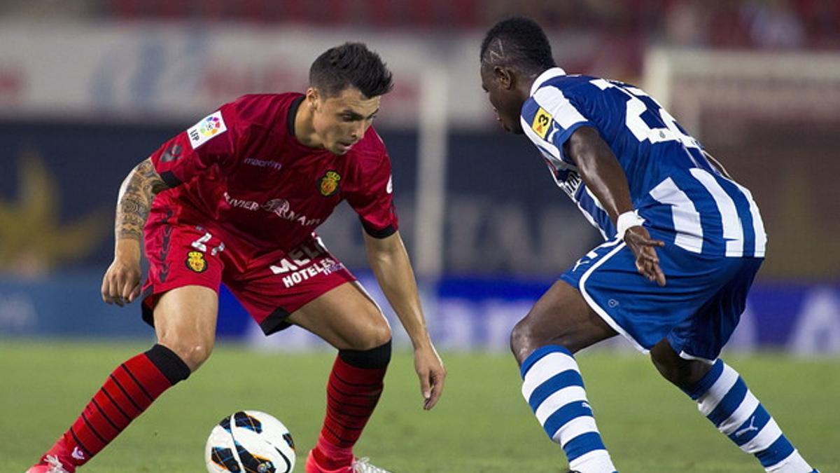 El defensa del RCD Mallorca, Ximo Navarro, intenta superar al centrocampista ghanés del RCD Español, Wakaso Mubarak, durante la primera jornada de primera división.