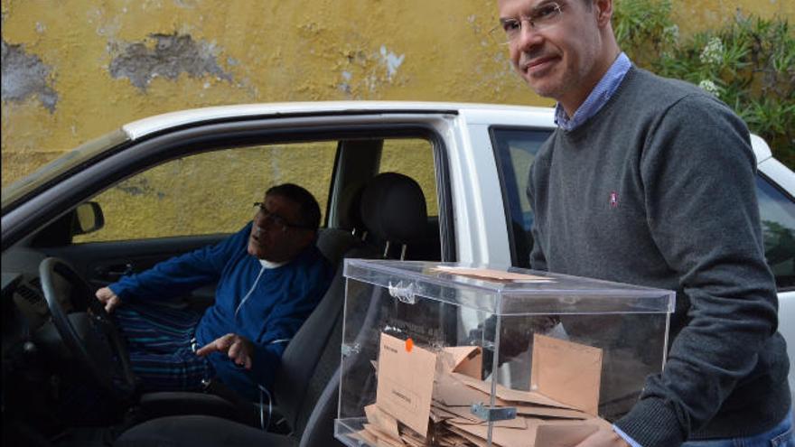 Un presidente de mesa saca la urna a la calle para que vote un ciudadano con discapacidad.