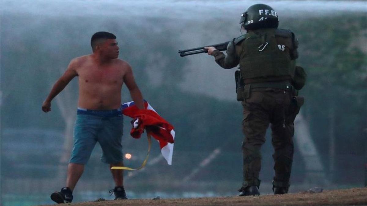 Un carabinero apunta a un manifestante chileno.