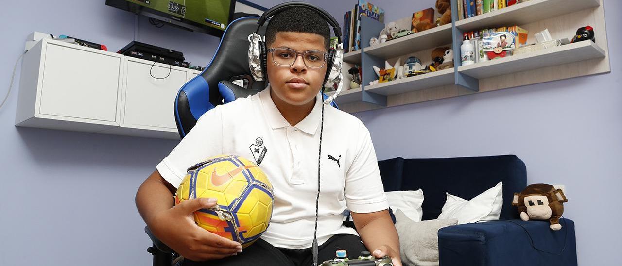 El joven vigués, en su cuarto, con un balón de fútbol y un mando de la PlayStation 4.