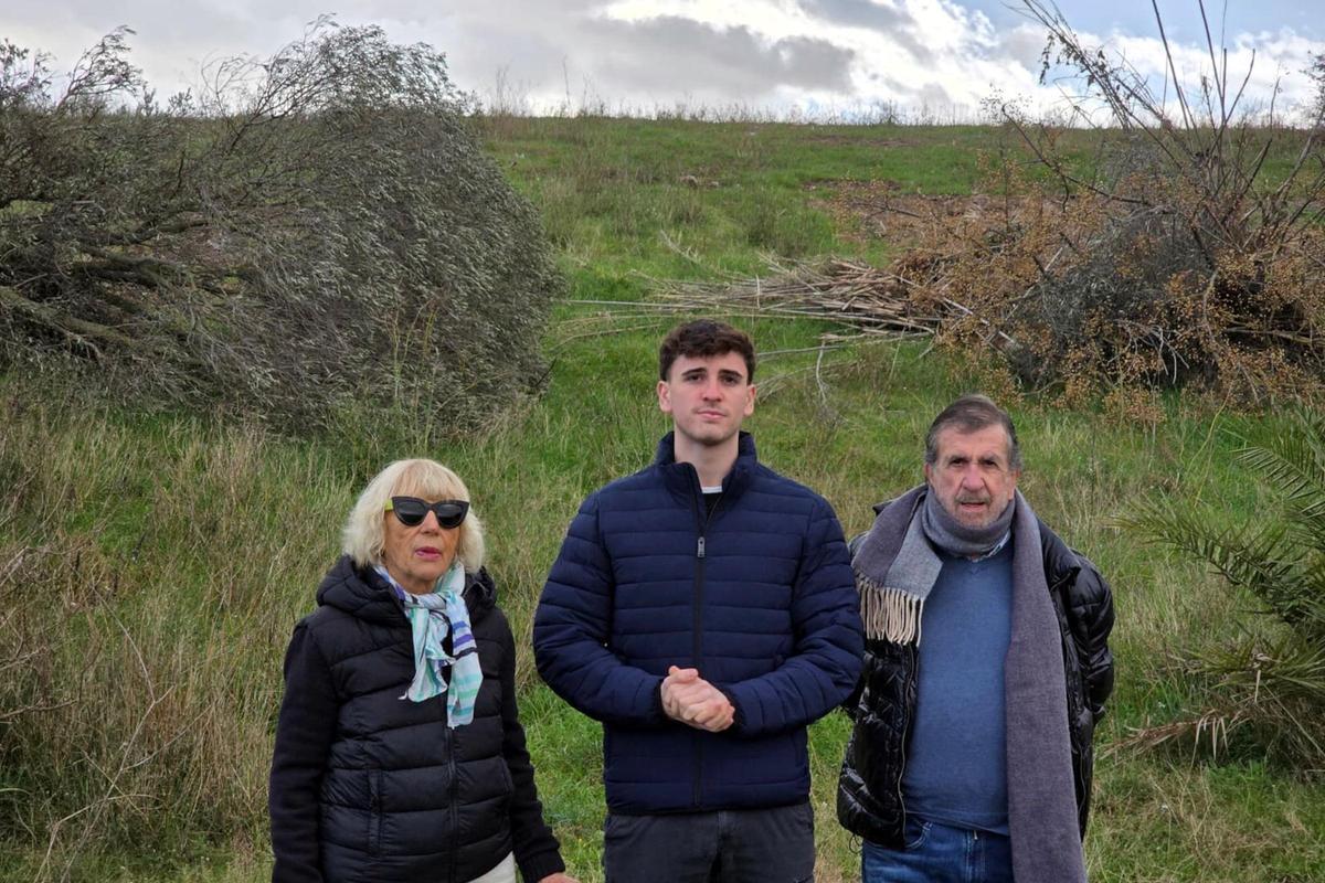 Al centre, Joan Sàlvia amb els seus avis. Darrere, el turó que amaga tones de brossa d'un antic abocador.