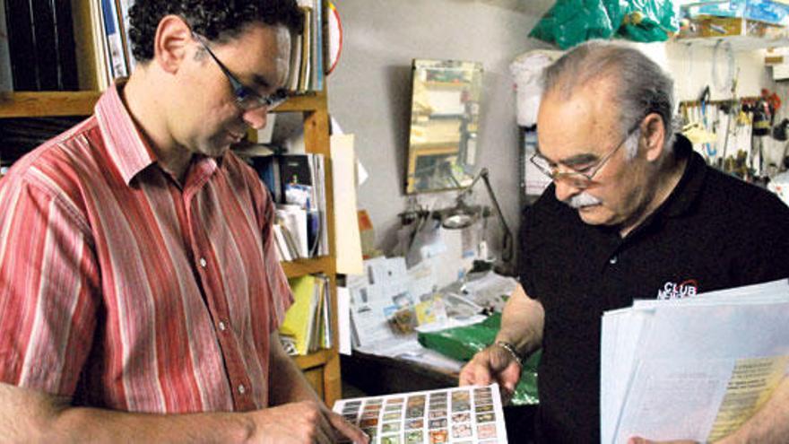 El presidente del Cercle Filatèlic de Manacor, Jaume Rigo, observa un libro de sellos que saldrán a subasta este mes de julio. Junto a él, a la derecha, el gran experto, el ´llorencí´ Eduard Perales.
