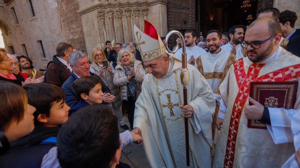 Benavent saluda a unos niños al salir de la Catedral de València tras su toma de posesión como arzobispo.