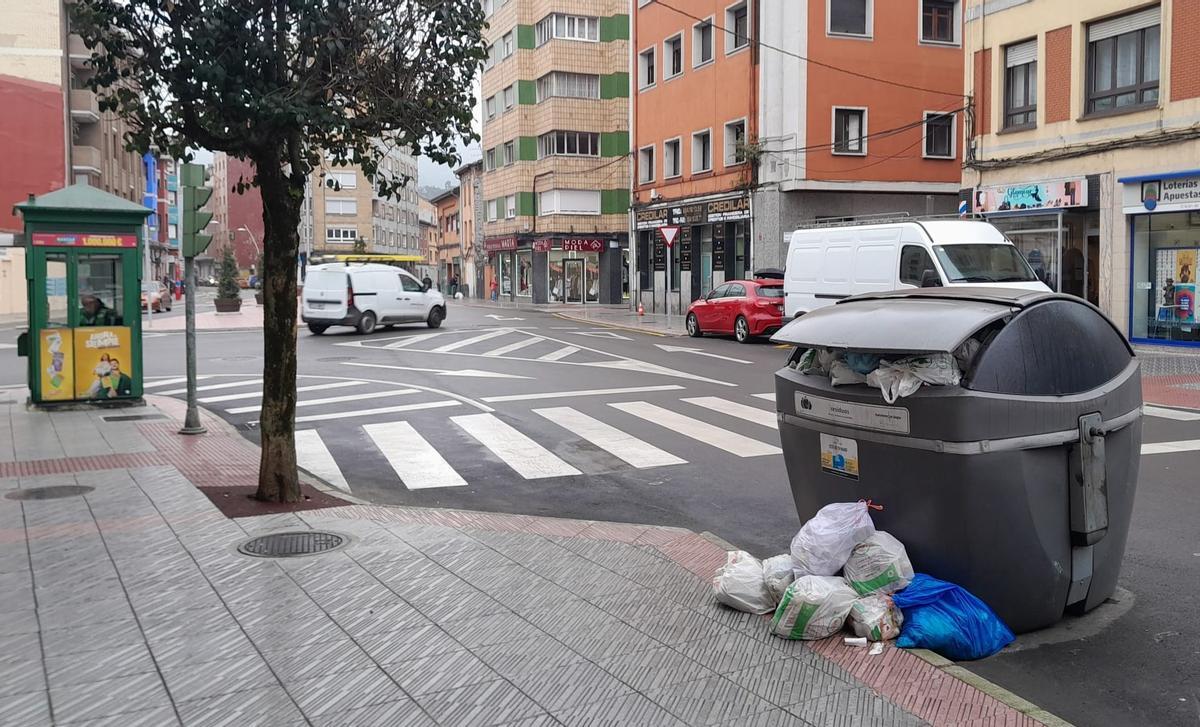 Un contenedor de la basura, lleno a rebosar y sin recoger en el entronque entre la calle Dorado y la plaza de la Salve en Sama.