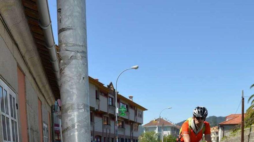 Un ciclista por el arcén de la PO-308 a su paso por Covelo. // G. Santos