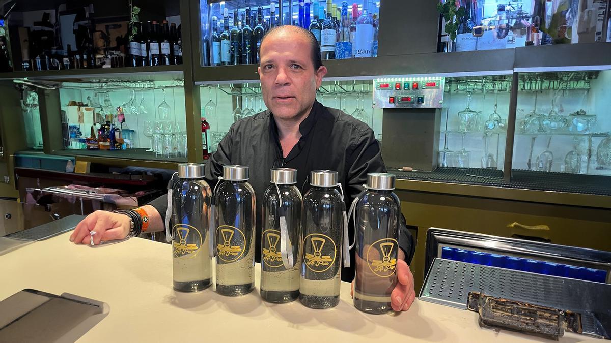 Héctor Méndez, "Tito", junto a las botellas reutilizables.