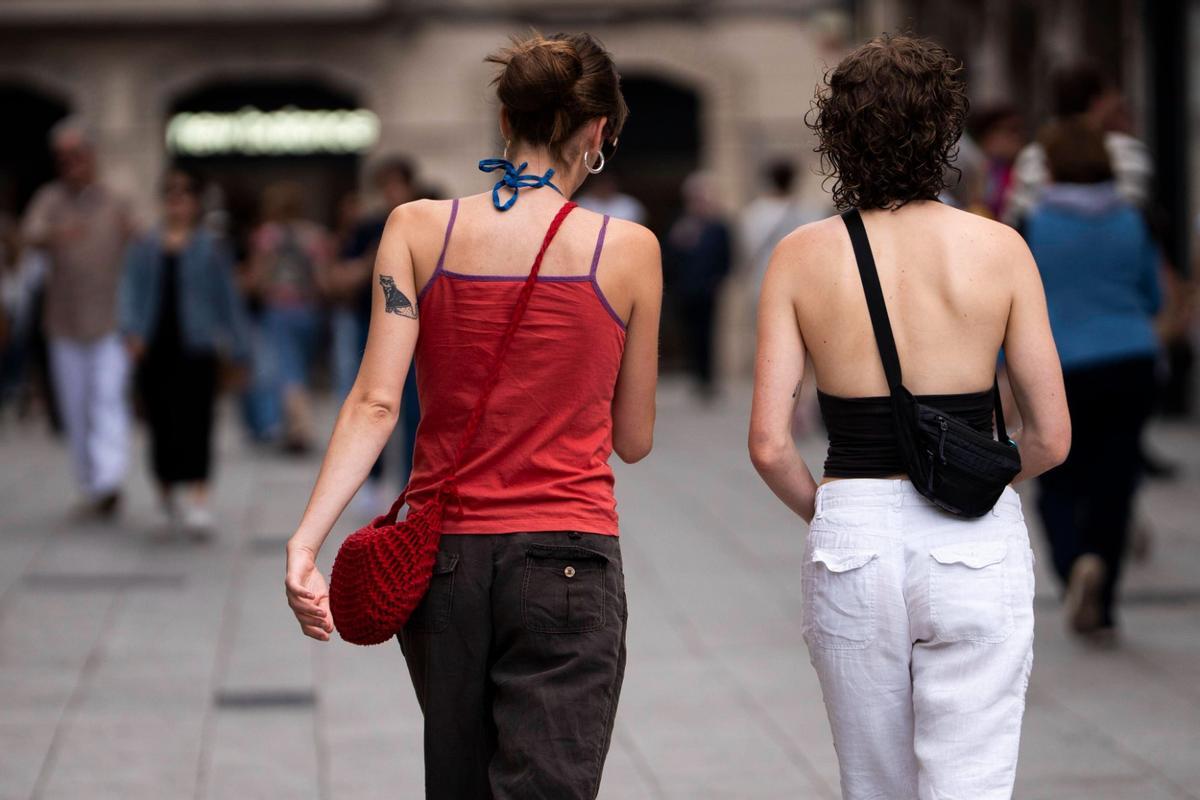 Dos jóvenes pasean por Barcelona, este verano.