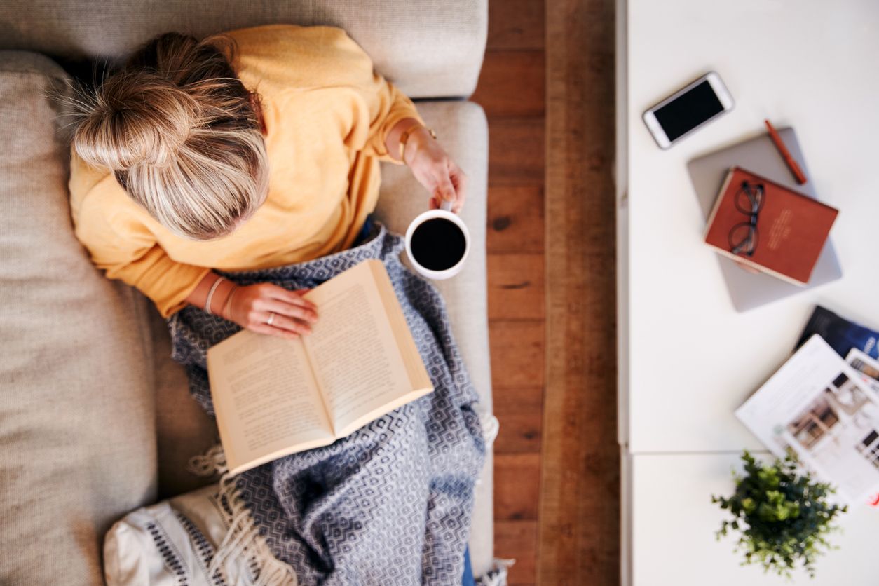 Mujer leyendo un libro en el sofá