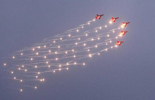 Patrouille Suisse Northrop F-5E Tiger II jet release flares during a flight demonstration at a Swiss Air Force commando handover ceremony at the Swiss Army Airbase in Duebendorf