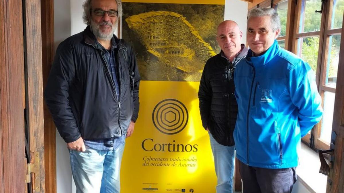 Javier Naves y Ernesto Díaz posan junto a Antonio Álvarez, del museo grandalés, ante un cartel de la muestra. | R. T. C.