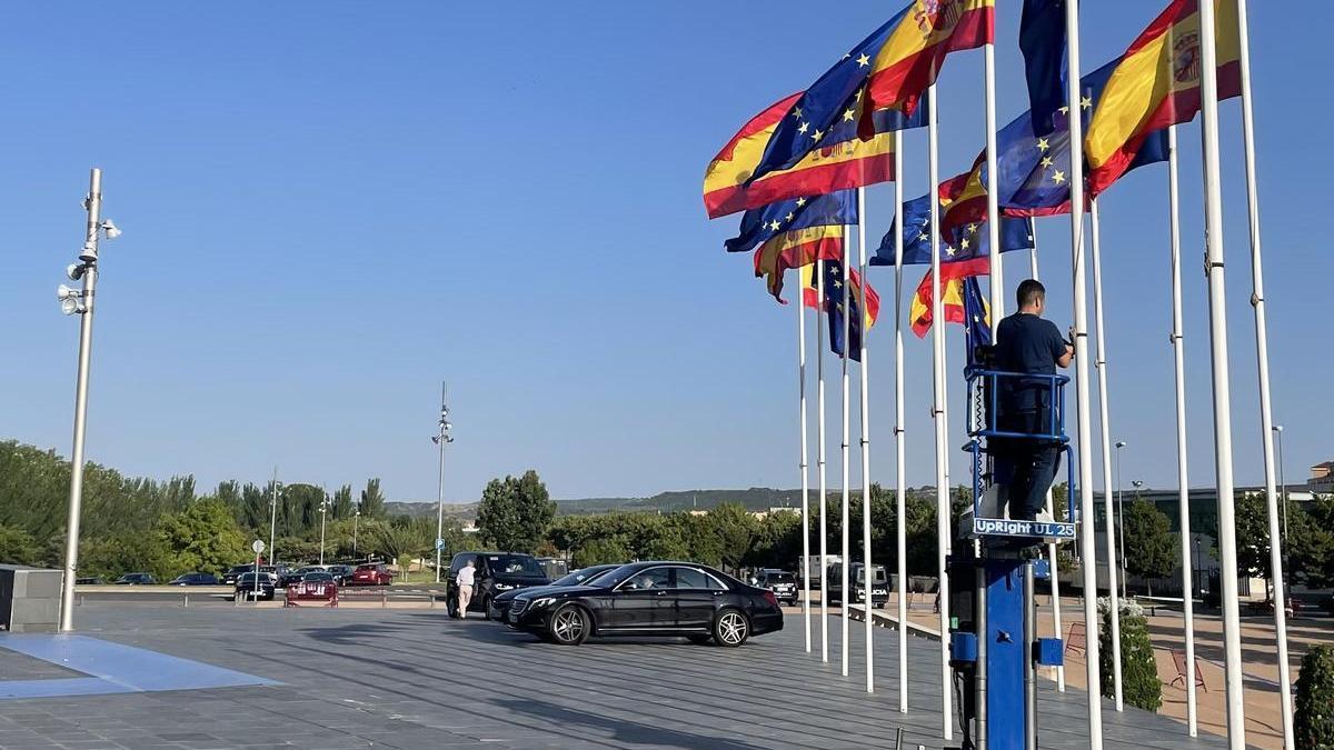 Un técnico iza las banderas que flanquean la entrada del Palacio de Congresos de La Rioja.