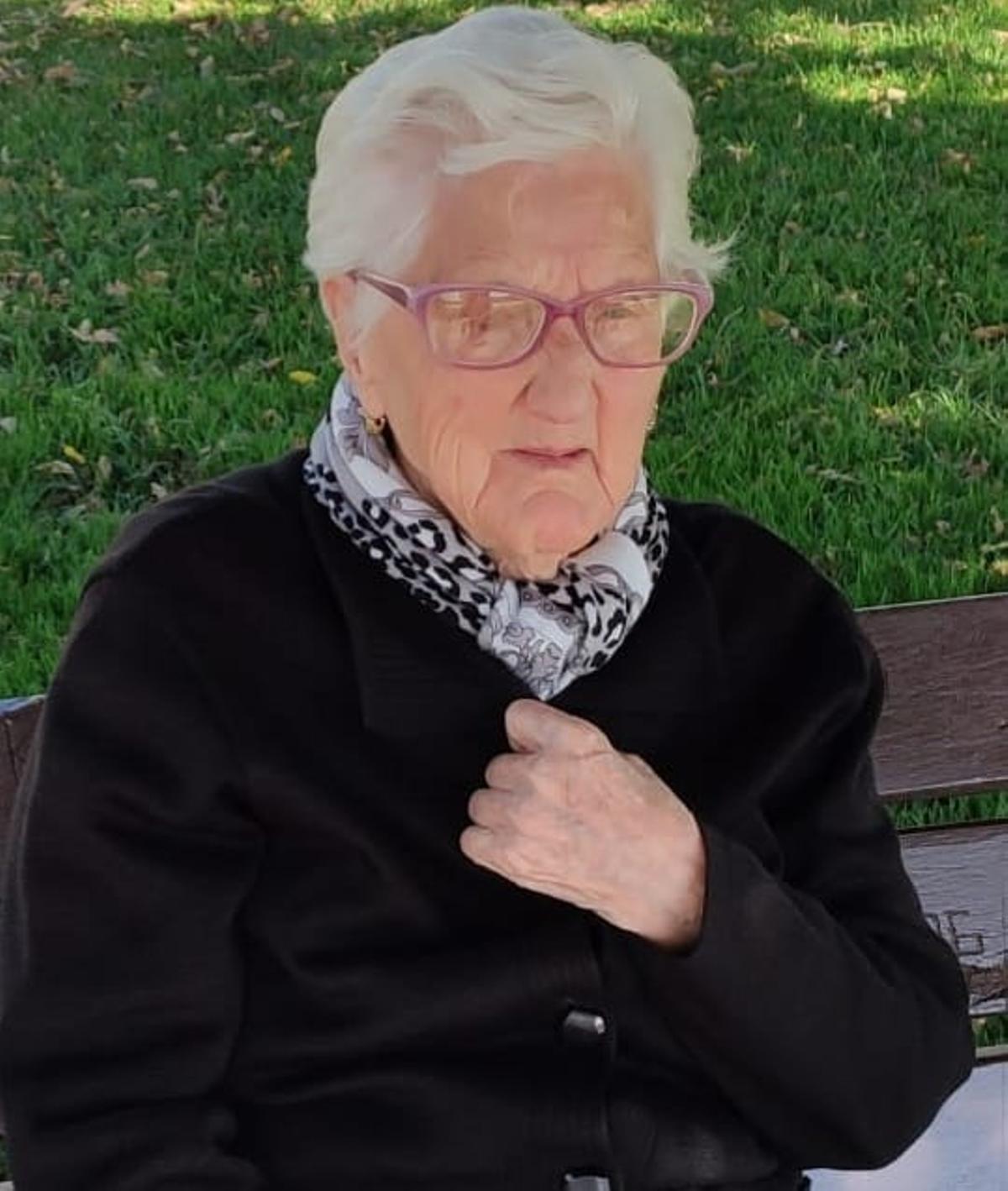 Isabel Domínguez, natural de Las Hurdes y nacida en 1920, sentada en un banco.