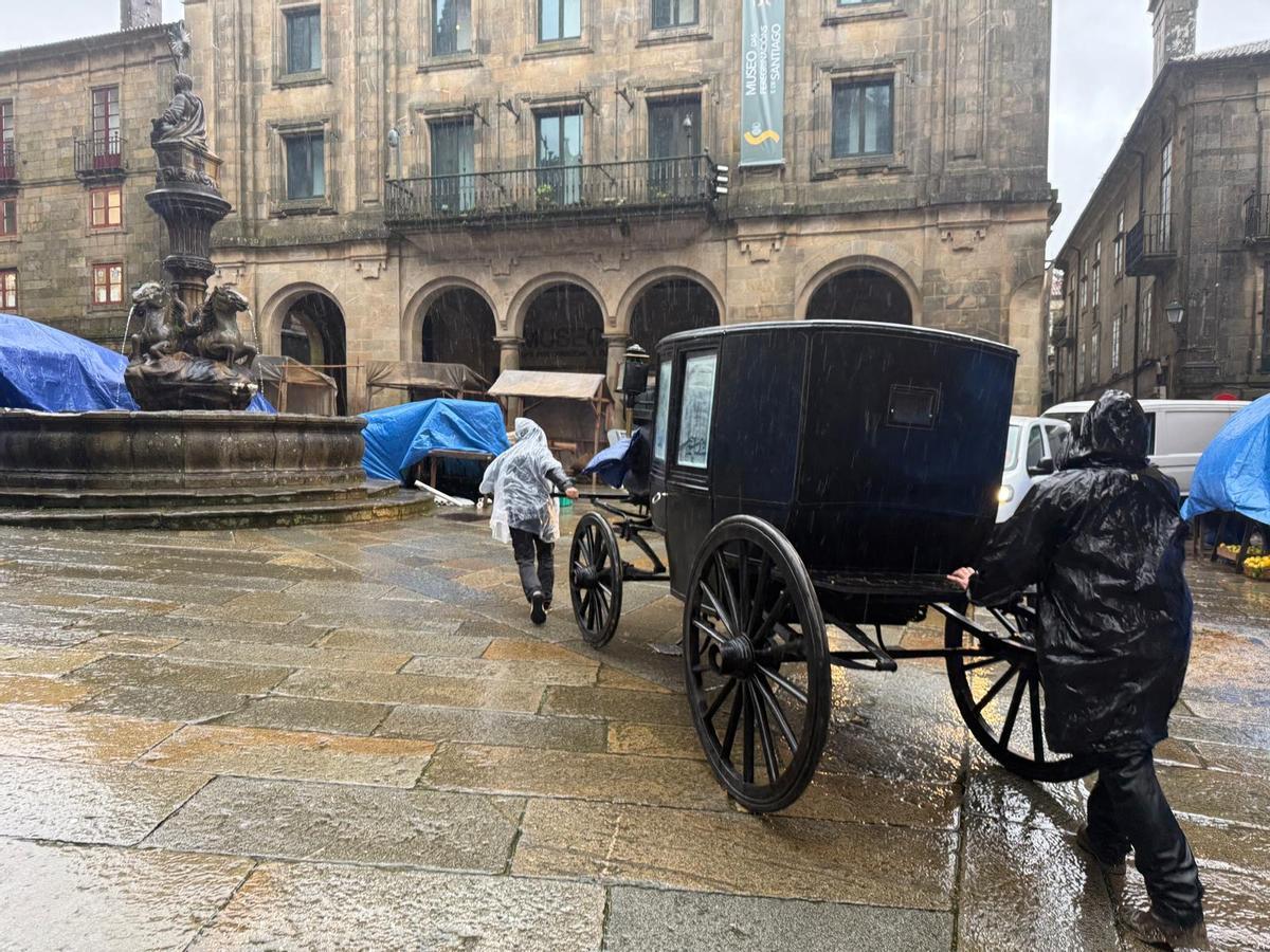 Varios operarios mueven un carruaje de época en la compostelana Praza das Pratarías