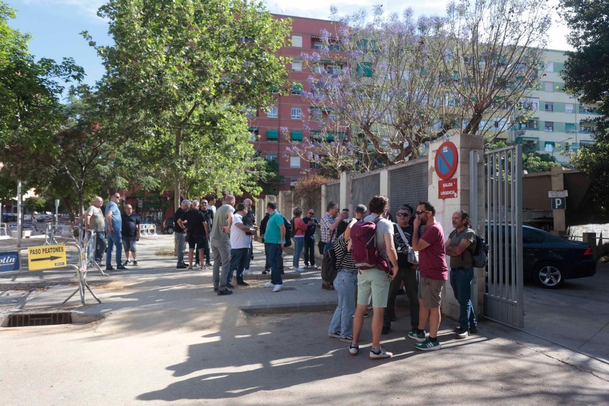 Un grupo de trabajadores se reúne en la puerta del IES Sorolla.